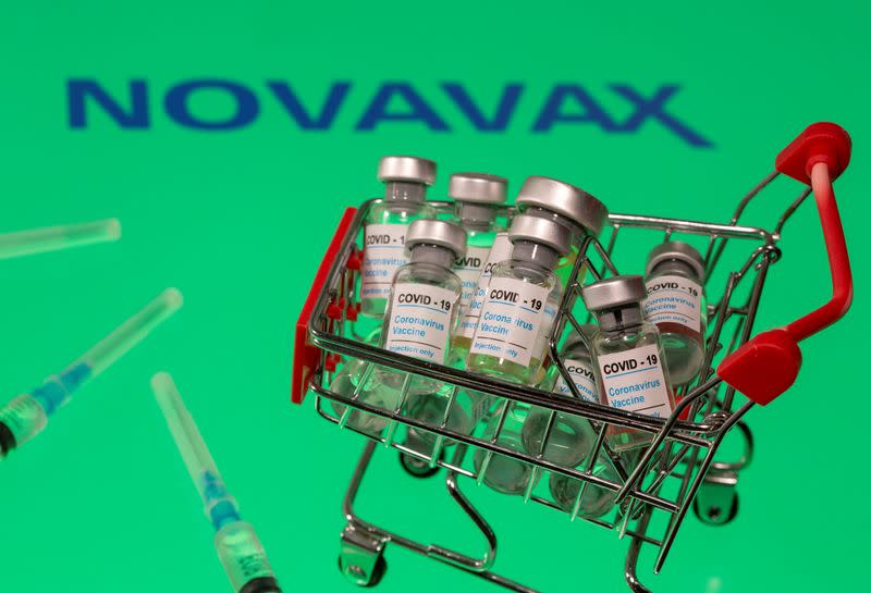 FILE PHOTO: A small shopping basket filled with vials labeled "COVID-19 - Coronavirus Vaccine" and medical sryinges are placed on a Novavax logo