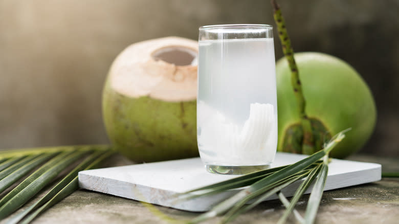 Glass of coconut water with palm leaf