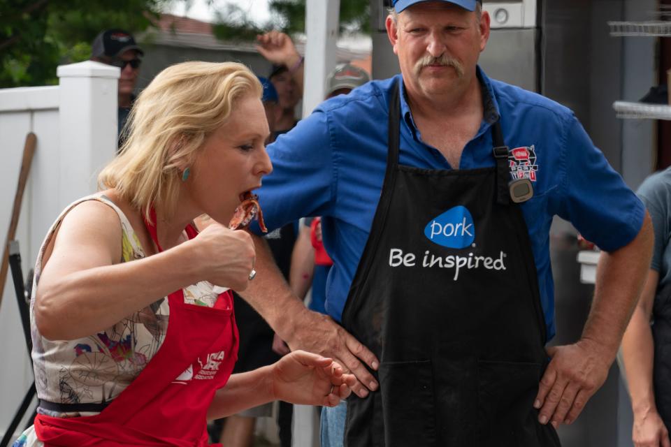 Gillibrand chomps on a piece of meat at the state fair on Aug. 10.