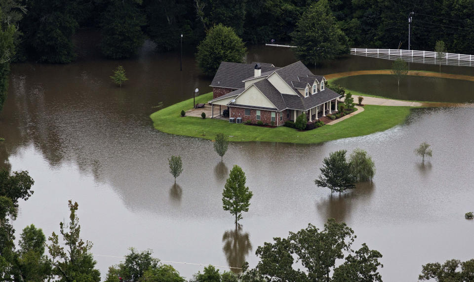 FILE- In this Aug.13, 2016 aerial photo over Amite, La., flooded homes are seen from heavy rains inundating the region. Memories of an epic flood that caused billions of dollars in damage had Louisiana's capital on edge Friday, July 12, 2019, as Barry gained strength in the Gulf of Mexico.(AP Photo/Max Becherer, File)