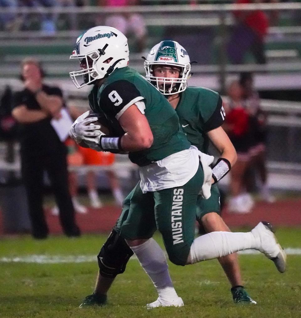Lakewood Ranch quarterback Colin Hait hands off to Simon Freed during Friday night's game against Palmetto.