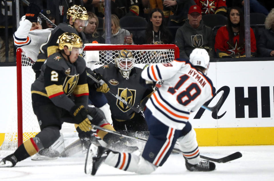 Edmonton Oilers left wing Zach Hyman (18) scores past Vegas Golden Knights goaltender Robin Lehner (90) during the second period of an NHL hockey game Friday, Oct. 22, 2021, in Las Vegas. Vegas Golden Knights defenseman Zach Whitecloud (2) looks on. (AP Photo/Steve Marcus)