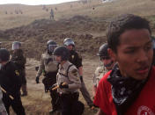 A line of police move towards a roadblock and encampment of Native American and environmental protesters near an oil pipeline construction site, near the town of Cannon Ball, North Dakota, U.S. October 27, 2016. REUTERS/Rob Wilson