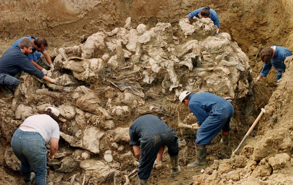 FILE - In this Sept. 18, 1996 file photo, International War Crimes Tribunal investigators clear away soil and debris from dozens of Srebrenica victims buried in a mass grave near the village of Pilica, some 55 kms (32 miles) north east of Tuzla, Boisnia-Herzegovina. The Dutch Supreme Court is ruling Friday July 19, 2019 in a long-running legal battle over whether the Netherlands can be held liable in the deaths of more than 300 Muslim men who were murdered by Bosnian Serb forces during the 1995 Srebrenica massacre.. (AP Photo/Staton R. Winter, File)