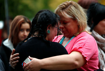 Women embrace near a memorial site for victims of the mosque shootings, at the Botanic Gardens in Christchurch, New Zealand, March 18, 2019. REUTERS/Edgar Su
