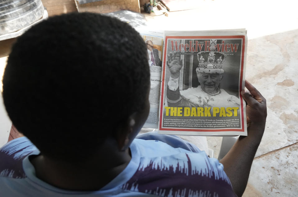 Un keniata lee el diario Daily Nation, que muestra una imagen del rey Carlos III y el titular "El pasado oscuro" en Nairobi, el domingo 29 de octubre de 2023. (AP Foto/Sayyid Abdul Azim)