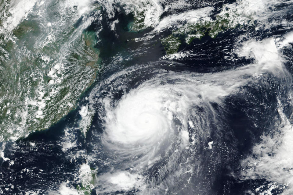 This Monday, Aug. 31, 2020, satellite image released by NASA shows Typhoon Maysak over Japan's southernmost islands, including Okinawa, center. The powerful typhoon was blowing over Japan's southernmost islands early Tuesday on course for Japan's main southern island and later the Korean Peninsula. Warnings issued for the area around Okinawa, home to U.S. military bases, said strong gusts could cause some homes to collapse and extremely high tides were a risk as well. (NASA Worldview, Earth Observing System Data and Information System (EOSDIS) via AP)