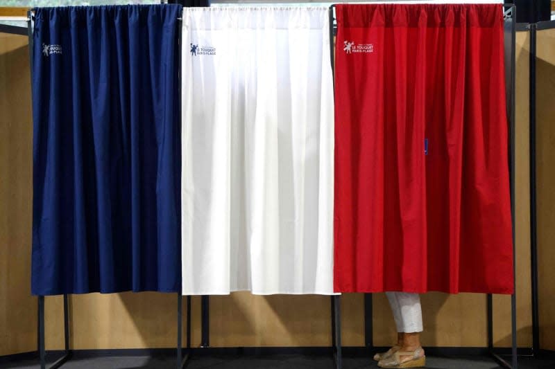 A woman votes at a polling station during the second round of the French parliamentary elections.  On July 7, 2024, France will hold parliamentary elections that will be decisive for the country's political future and in which the extreme right could become the largest party in parliament for the first time.  Ludovic Marin/AFP/dpa