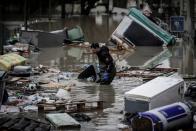 <p>A resident cleans debris from a flooded street in Villeneuve-Saint-Georges, south of Paris, on Jan. 25, 2018. (Photo: Philippe Lopez/AFP/Getty Images) </p>