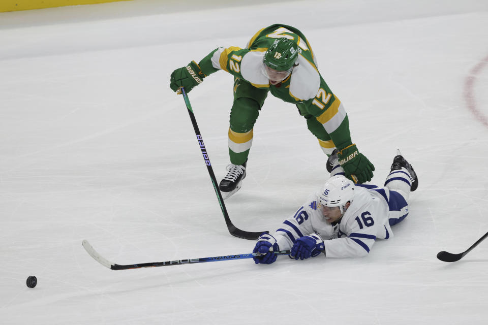 Toronto Maple Leafs right wing Mitchell Marner (16) and Minnesota Wild left wing Matt Boldy (12) go after the puck during the first period of an NHL hockey game Friday, Nov. 25, 2022, in St. Paul, Minn. (AP Photo/Stacy Bengs)