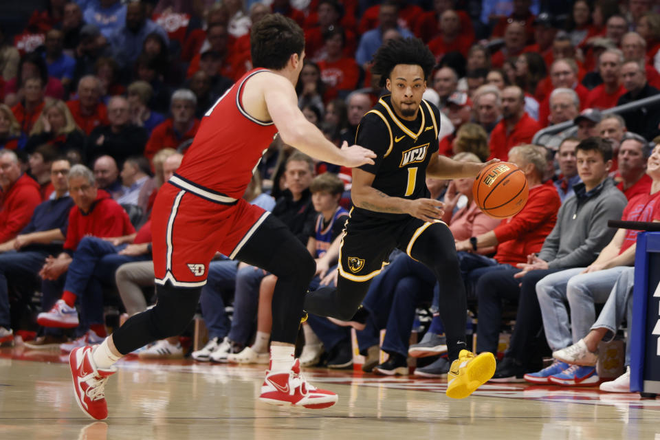 Virginia Commonwealth's Jason Nelson, right, tries to dribble past Dayton's Nate Santos, left, during the first half of an NCAA college basketball game Friday, March 8, 2024, in Dayton, Ohio. (AP Photo/Jay LaPrete)