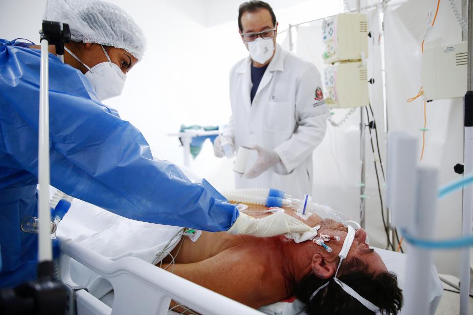 Nurse technician Larissa Bezerra (L) and nursing supervisor Mauricio Fernandes care for a Covid patient in the Intensive Care Unit (ICU) of a former men’s hospital, which has been converted into a field hospital for Covid patients in Sao Paulo, Brazil (Getty Images)