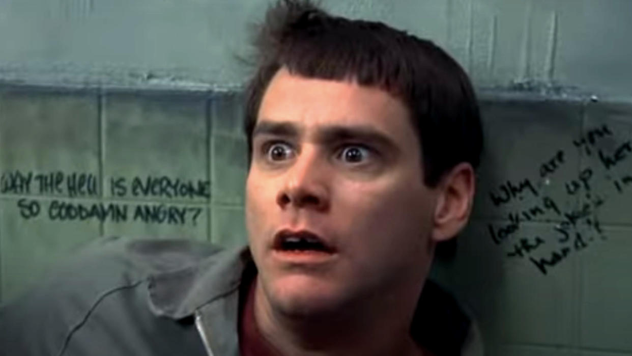  Jim Carrey backed against a bathroom wall with a look of horror in Dumb and Dumber. 