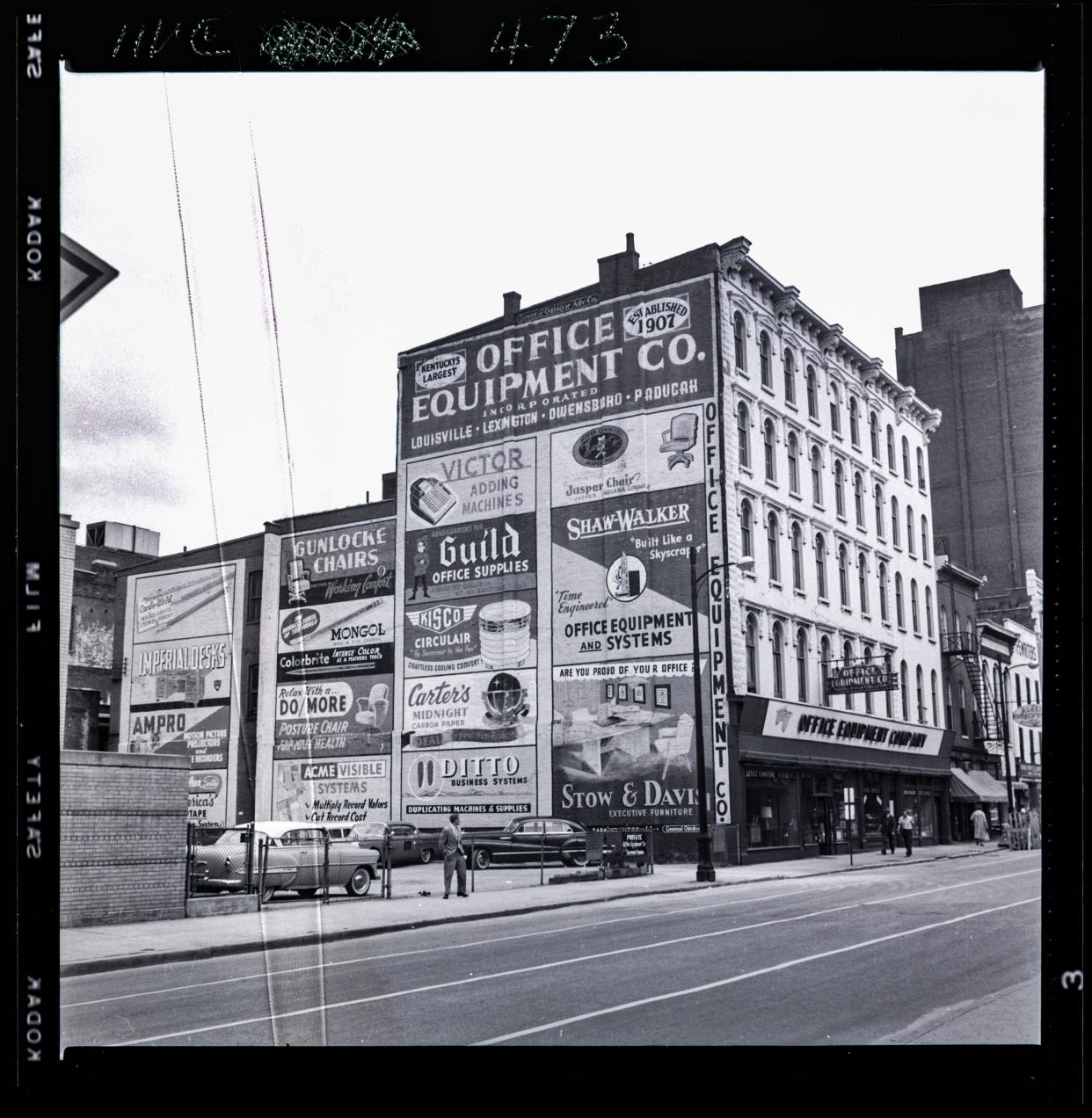 Advertising signs adorn the Office Equipment Company building at 119 S. 4th St. The building no longer exists.