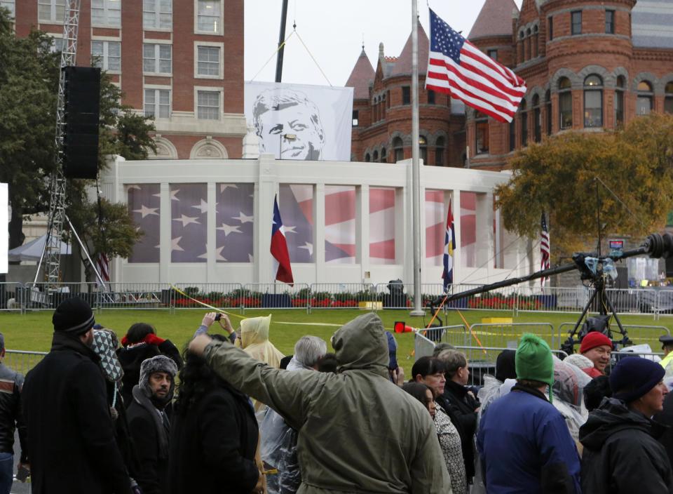 A banner of President John F. Kennedy is pulled into place in Dealey Plaza prior to 50th anniversary ceremonies of JFK's assassination in Dallas