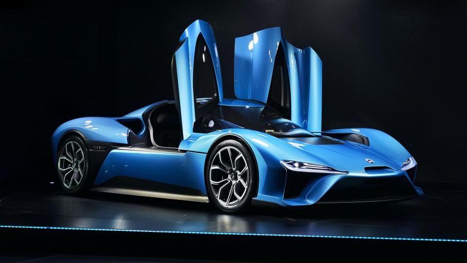 Blue sportscar with doors open vertically.