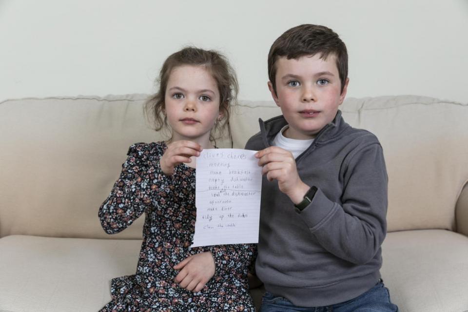 York Press: From left: Violet, five, and Clive, six, hold Clive's chore list. Picture: SWNS