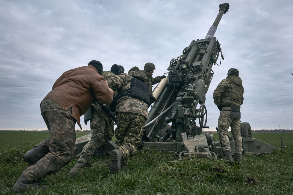 Ukrainian soldiers prepare a U.S.-supplied M777 howitzer to fire at Russian positions in Kherson region, Ukraine, Jan. 9, 2023. (AP Photo/Libkos)