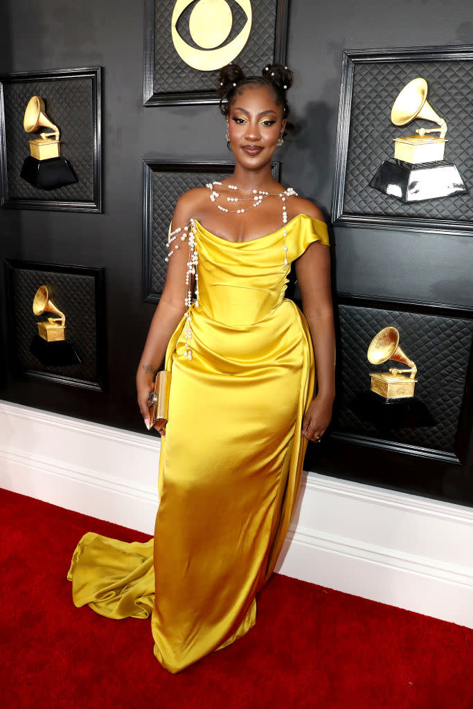 Tems in low-cut yellow silk gown. 
