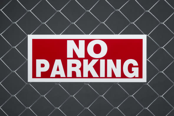 'No parking' sign on chain link fence