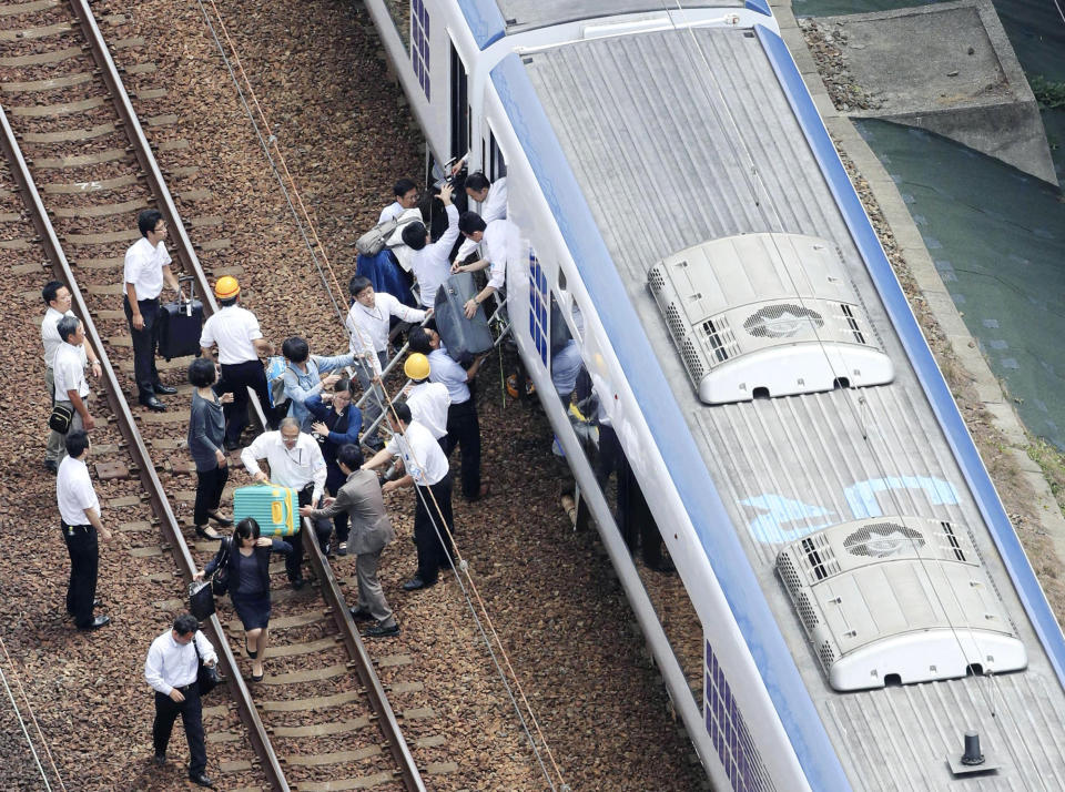 <p>Passengers descend from a train on the track after train service was suspended to check for damage following an earthquake in Takatsuki city, Osaka, western Japan, Monday, June 18, 2018. (Photo: Kyodo News via AP) </p>