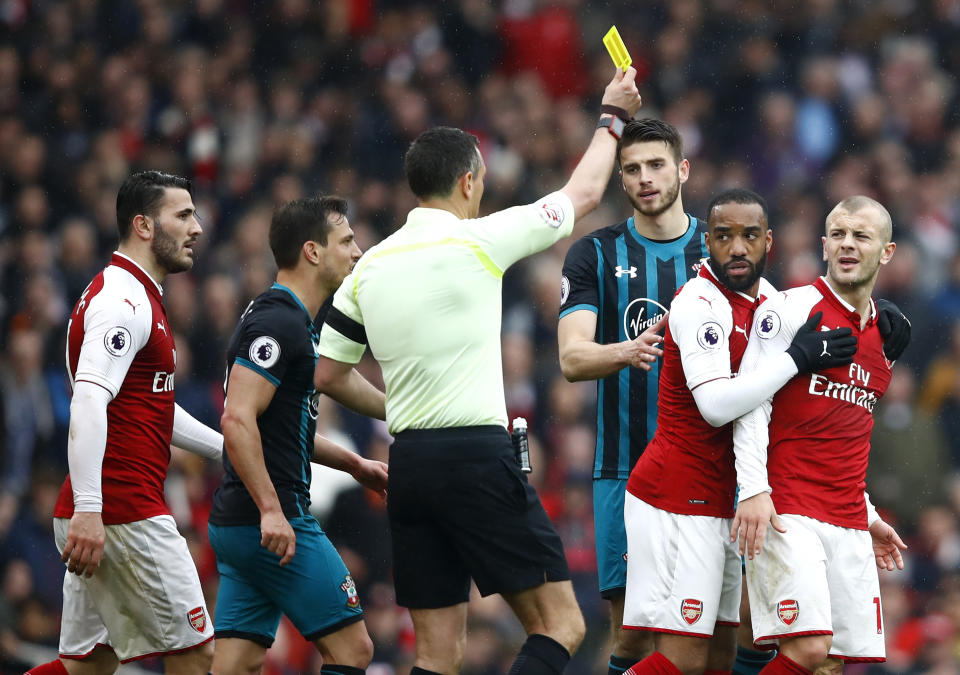 Jack Wilshere is shown a yellow card by referee Andre Marriner during the Premier League match between Arsenal and Southampton.