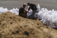 Ukrainian service members pack sandbags to be used as fortifications in the Donetsk region, eastern Ukraine, Wednesday, Aug. 3, 2022. (AP Photo/David Goldman)