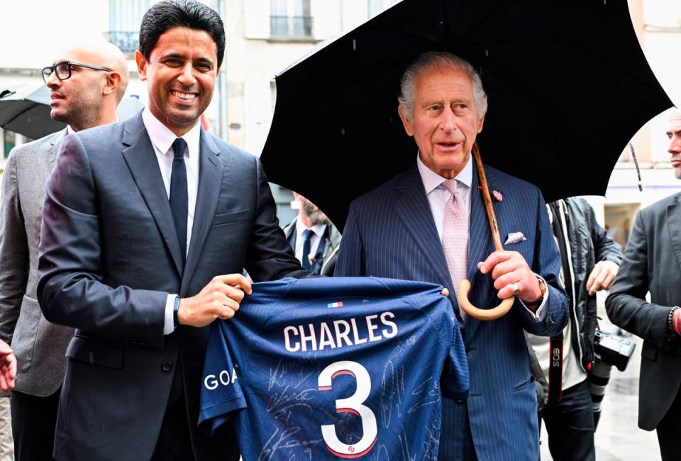 Paris Saint Germain's president Nasser Al-Khelaifi offers Charles a PSG jersey on Thursday in Saint-Denis (AP)