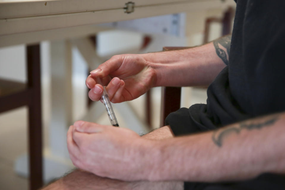 Lucas injects his weekly testosterone shot as part of his hormone therapy on May 29, 2023 in Casselberry, Fla. The Associated Press is not using Eli’s and Lucas’ last names because they fear reprisal. Lucas only has one refill left before he runs out of testosterone. The clinic that previously prescribed his medication has stopped providing gender affirming care after a recent law banned nurse practitioners from being providers. Lucas worries that without access to testosterone, he'll start to detransition. (AP Photo/Laura Bargfeld)