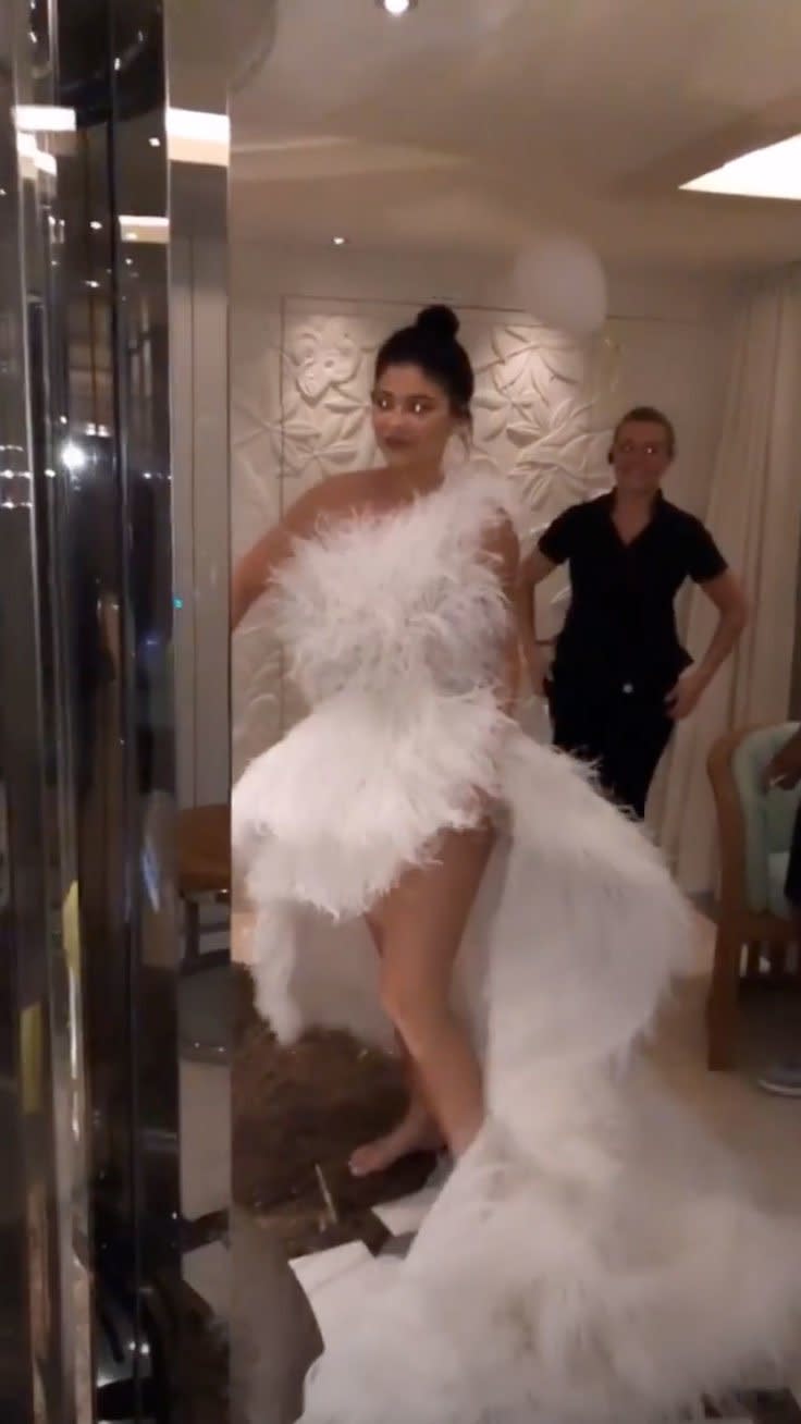 Kylie changed into another feathered look, this time a white gown that people initially <a href="https://people.com/tv/kylie-jenner-and-travis-scott-arent-getting-married-during-her-birthday-trip-in-italy-source/" rel="nofollow noopener" target="_blank" data-ylk="slk:thought was a wedding dress;elm:context_link;itc:0;sec:content-canvas" class="link ">thought was a wedding dress</a>. 