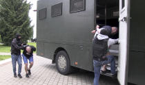 In this photo taken from video released by Belarusian KGB, State TV and Radio Company of Belarus on Wednesday, July 29, 2020, Belarusian KGB officers detain Russian men in a sanitarium outside in Minsk, Belarus. Belarusian officials said that more than 30 detained employees of private Russian military contractor Wagner are facing a criminal probe on charges of plotting terror attacks in Belarus amid a presidential election campaign. (Belarusian KGB, State TV and Radio Company of Belarus via AP)