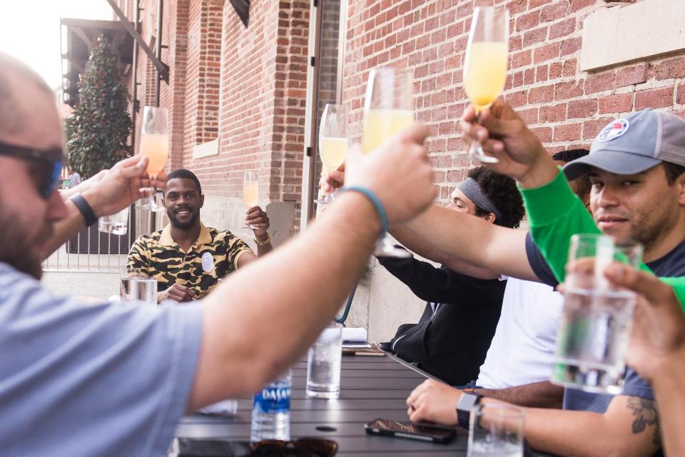 Averitt Scott and his bachelor's party raise a glass outside of Plant Riverside on Saturday. The group chose Savannah to celebrate Scott's upcoming nuptials.