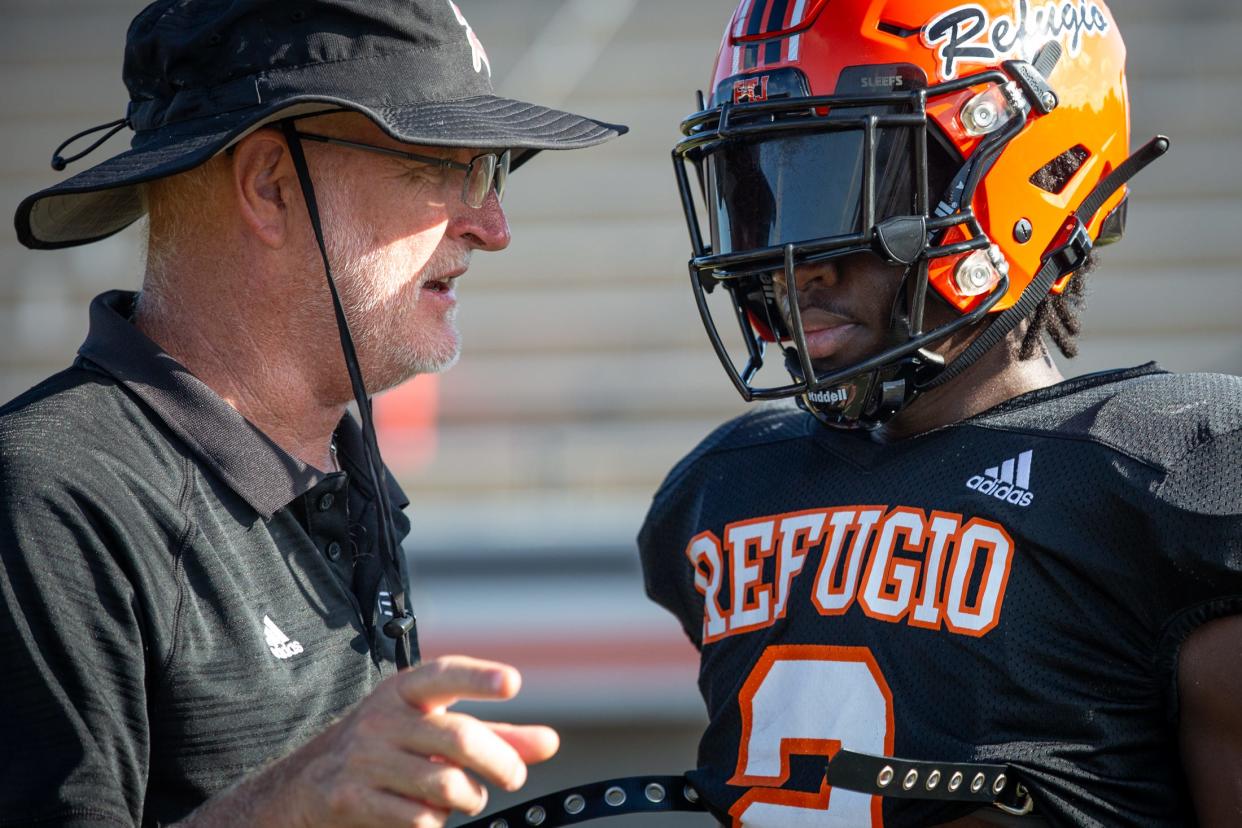 Refugio head football coach Jason Herring speaks to Chai Whitmire during practice at the high school on Aug. 4, 2023, in Texas.
