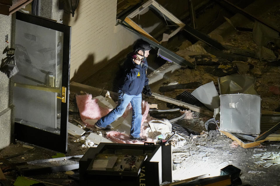 An official surveys an area near the back entrance to the Sandman Signature hotel following an explosion, Monday, Jan. 8, 2024, in Fort Worth, Texas. (AP Photo/Julio Cortez)