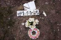 Flowers are placed on the grave of an unidentified migrant, who drowned at sea during an attempt to cross a part of the Aegean Sea from the Turkish coast, at the Saint Panteleimon cemetery of Mytilene, on the Greek island of Lesbos, October 7, 2015. REUTERS/Dimitris Michalakis