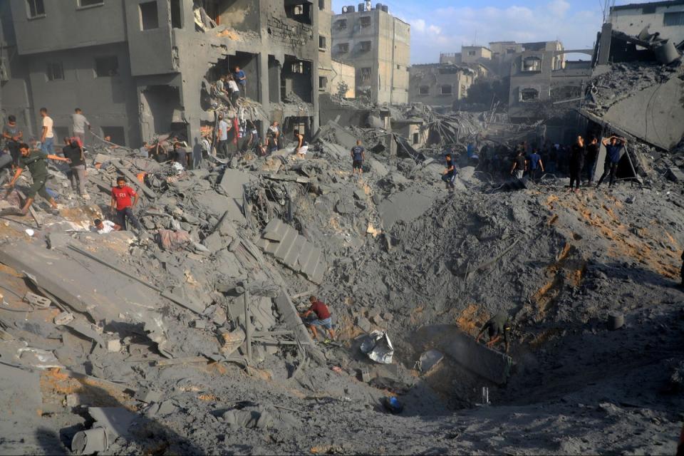 Palestinians look for survivors among the rubble of destroyed buildings following Israeli airstrikes on Jabaliya refugee camp (AP)