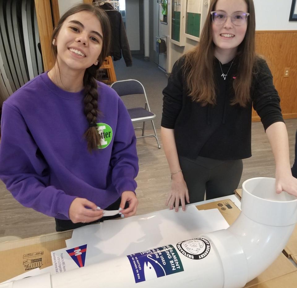 Ava Collino and Kira Goldsmith work at the label and graphics station at the recent workshop.