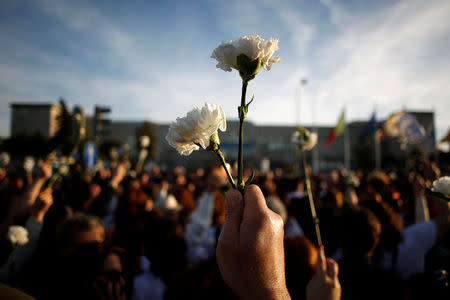 Nurses wave white carnations in front of Santa Maria Hospital during a protest march in Lisbon, Portugal, March 8, 2019. REUTERS/Pedro Nunes