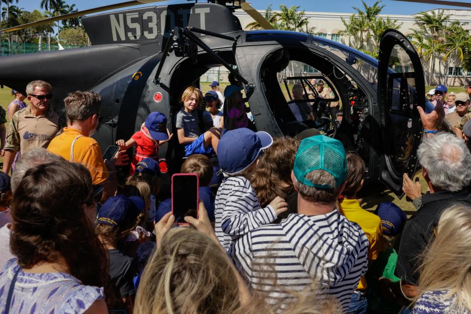 People get a closeup view of a helicopter during Saturday's Navy Seal Day at the Mandel Recreation Center. The event, which included family friendly activities, was held courtesy of the Palm Beach Navy SEAL Evening of Tribute and the Navy SEAL Museum.