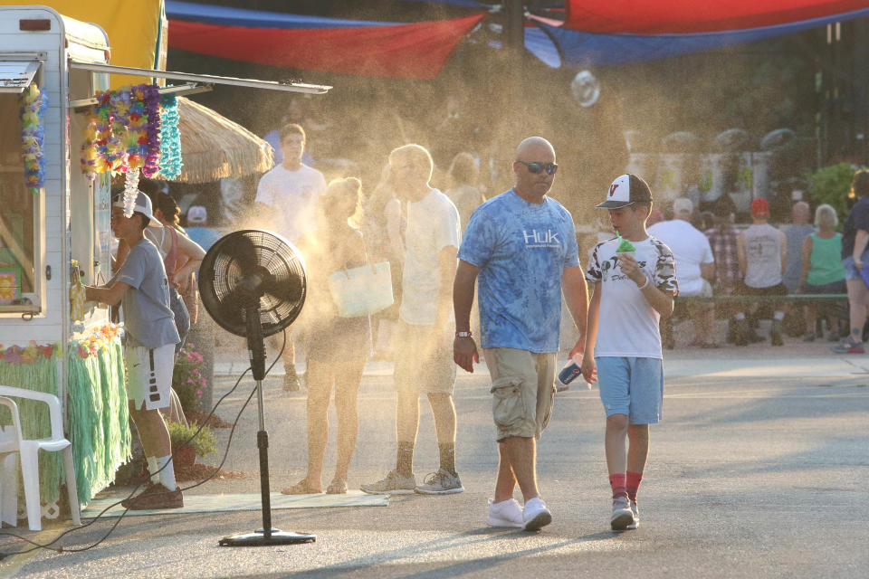 Attendees at the Delaware State Fare cool off during a heatwave on Friday.