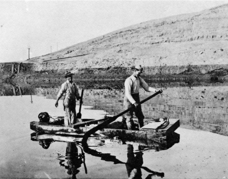 Men row on the lake of oil created by the 1910 Lakeview Gusher.