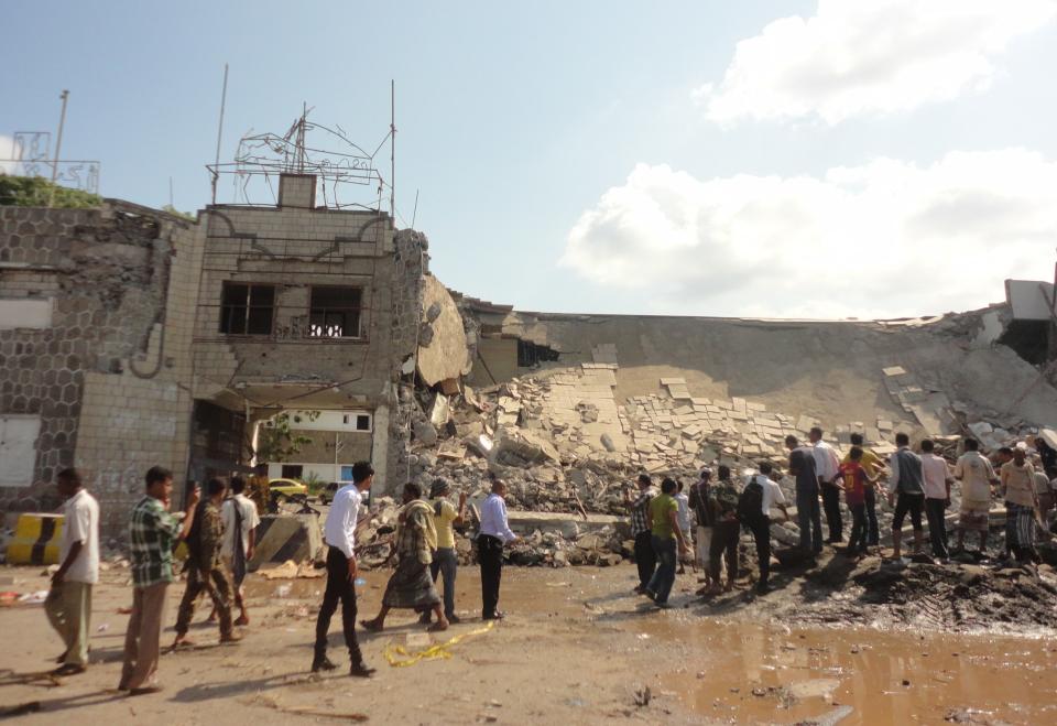 People gather at the scene of a car bomb attack on a police compound in the southern Yemeni city of Aden December 31, 2013. A suicide bomber drove a car laden with explosives into the compound on Tuesday, blowing himself up and wounding four police, security sources said. REUTERS/Yaser Hasan (YEMEN - Tags: POLITICS CRIME LAW CIVIL UNREST TPX IMAGES OF THE DAY)