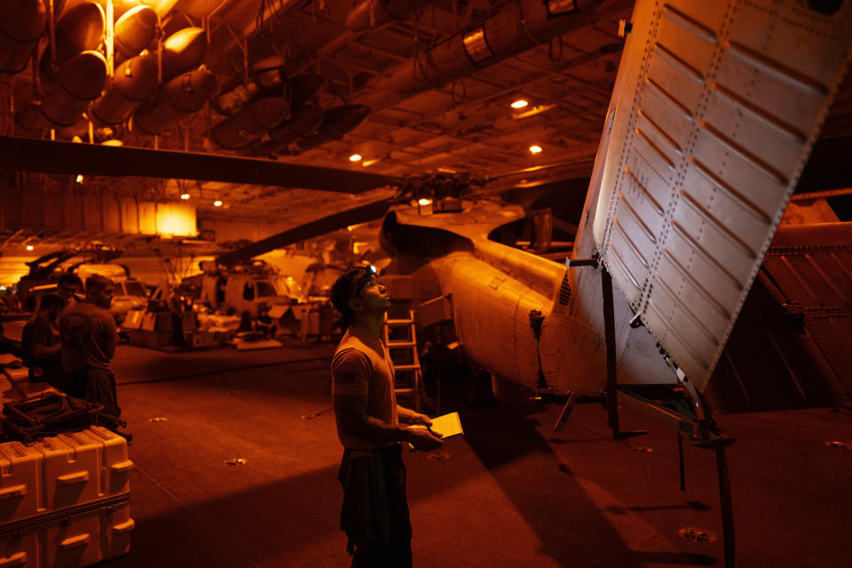 A crew member checks a helicopter in the hangar bay of the USS Dwight D. Eisenhower in the Red Sea on Tuesday, June 11, 2024.(AP Photo/Bernat Armangue)