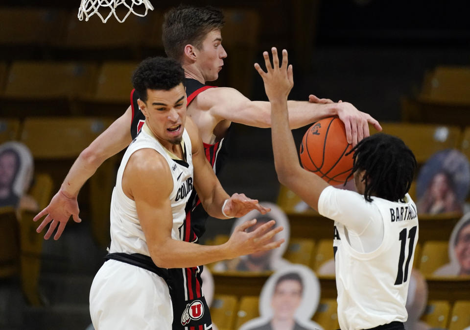 Utah center Branden Carlson, back left, blocks a shot by Colorado guard Keeshawn Barthelemy, right, as Colorado guard Maddox Daniels, front left, tries to clear out of the way in the second half of an NCAA college basketball game Saturday, Jan. 30, 2021, in Boulder, Colo. (AP Photo/David Zalubowski)