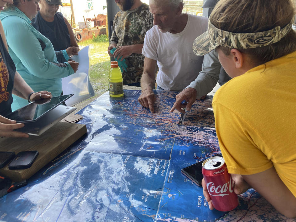 Volunteers gather around a map of the Louisiana coast Thursday, April 29, 2021, in Cocodrie, La., as they search for survivors of the Seacor Power, a lift boat that capsized off the coast on April 13. (AP Photo/Rebecca Santana)