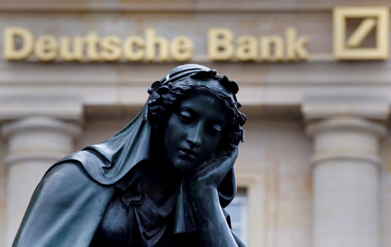FILE PHOTO: A statue is seen next to the logo of Germany's Deutsche Bank in Frankfurt