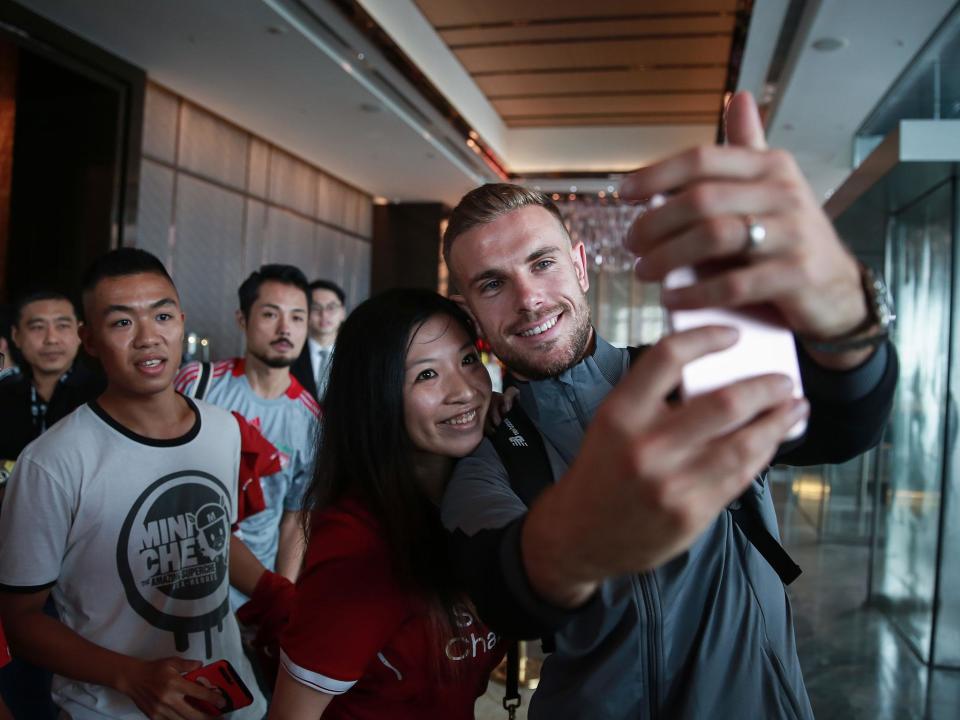 Jordan Henderson poses with a fan in Hong Kong: Getty