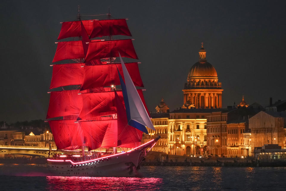 A brig with scarlet sails sailing on the Neva River during a rehearsal for the Scarlet Sails festivities marking school graduation in St. Petersburg, Russia, late Wednesday, June 22, 2022. (AP Photo/Dmitri Lovetsky)