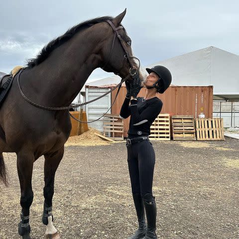<p>Bella Hadid/Instagram</p> Bella Hadid plants a kiss on one of the horses at her Florida equestrian club.