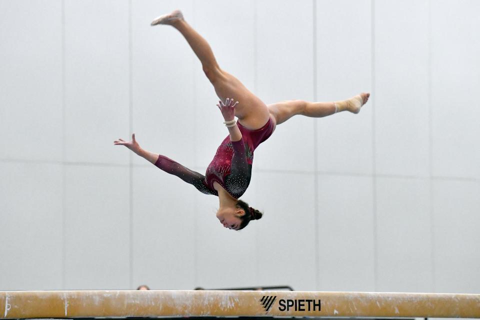 Kayla DiCello performs on the balance beam.